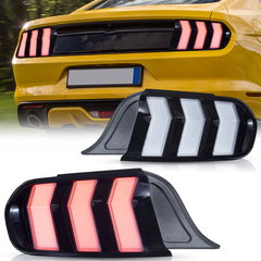 A pair of VLAND LED taillights for the 2015-2023 Ford Mustang S550, displayed in clear and red lens options. A Ford Mustang car is visible in the background, illustrating the product's application.